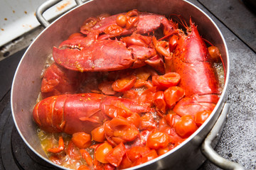 Astici cucinati rossi in pentola con pomodori