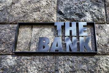 Bank office sign on the old stone wall