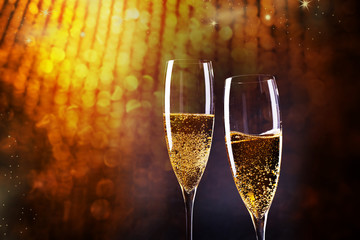 toasting with champagne glasses against holiday lights