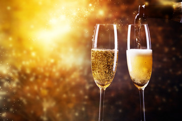 toasting with champagne glasses against holiday lights