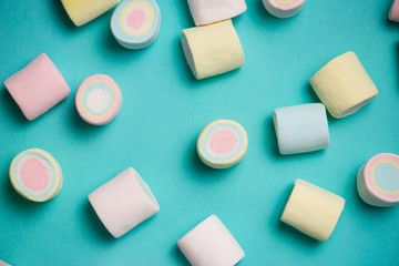 Top view of pastel colored marshmallow on a blue background. Min