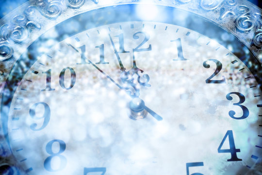 old clock with fireworks and holiday lights