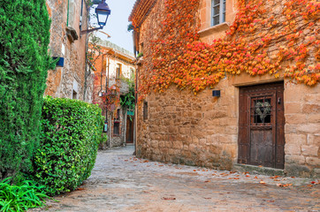 Fototapeta premium A street in the old town of Peratallada, Catalonia, Spain. Medieval street in the mediaval town in Europe. Panoramic view of old town in beautiful evening light at sunset. 
