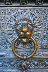 beautiful bronze knocker in the shape of lion head at  the gate of the Cologne Cathedral, the most famous church in Germany, the world cultural heritage of UNESCO