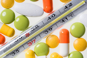 Nahaufnahme Tabletten und Fieberthermometer Quecksilber