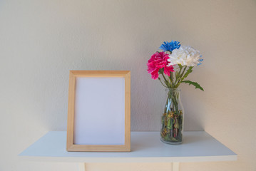 photo Frame on a wooden and Flowers in jar on White background .