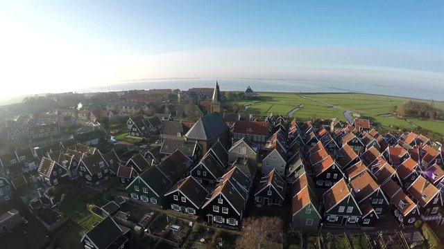 Aerial of Marken flying sideways near homes and church typical Dutch village it forms peninsula in Markermeer and was formerly island in Zuiderzee characteristic wooden houses are a tourist attraction