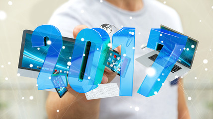 Businessman holding 2017 3D rendering text with tech devices