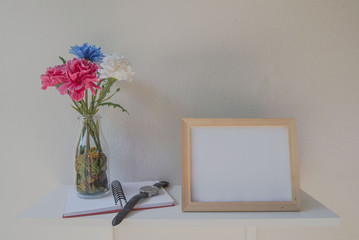 photo Frame on a wooden and Flowers in jar ,book on White background .