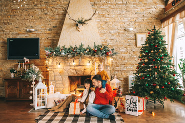 Fototapeta premium Young family in Christmas interior