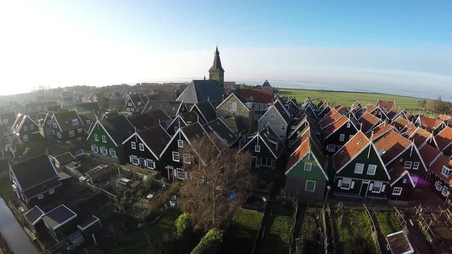 Aerial of Marken flying towards homes and church typical Dutch village it forms peninsula in Markermeer and was formerly island in Zuiderzee characteristic wooden houses are a tourist attraction 4k