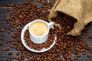 cup of coffee and beans on wooden background