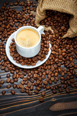 cup of coffee and beans on wooden background