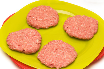 Four raw pork chops are on a plate