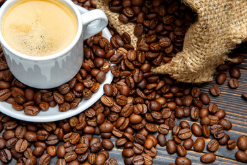 cup of coffee and beans on wooden background
