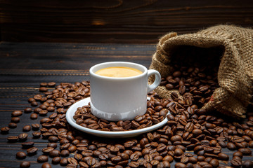 Obraz premium cup of coffee and beans on wooden background