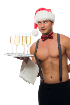 waiter in a cap of Santa Claus with a beautiful body brought champagne