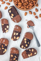 Homemade dark chocolate biscotti cookies with almonds, covered with melted chocolate, vertical, top view