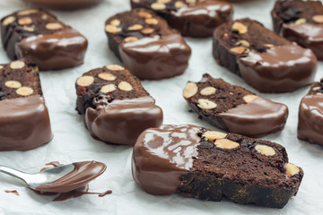Homemade dark chocolate biscotti cookies with almonds, covered with melted chocolate, horizontal
