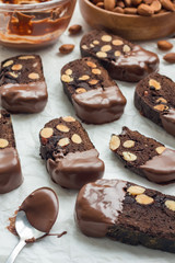 Homemade dark chocolate biscotti cookies with almonds, covered with melted chocolate, vertical