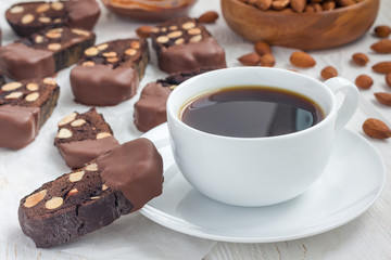 Homemade dark chocolate biscotti cookies with almonds, covered with melted chocolate, and cup of...