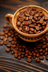 mug with roasted coffee beans on wooden background