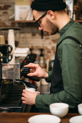 Man hands pours drink from a coffee machine.