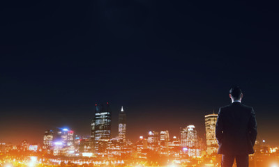 Businessman viewing night glowing city