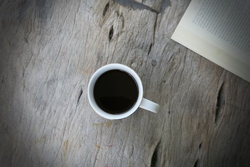 Coffee and open book on wooden table vintage background