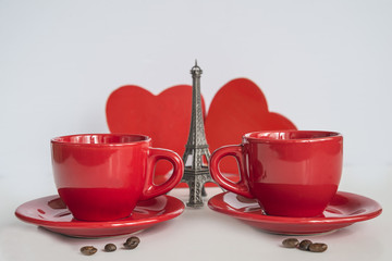 valentine concept/two res cups of coffee, eiffel tower and two red hearts on white background
