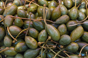 Green pickled big capers close up background