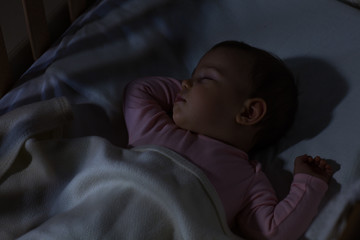 Baby Sleeping on the bed / Adorable baby sleeping at night. Little girl in pajama taking a nap in dark room.