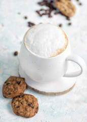 Cup of cappuccino in white mug with healthy cookies