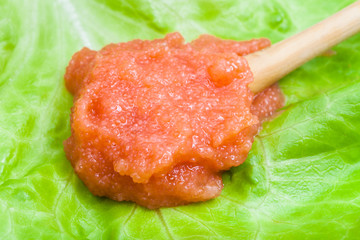 caviar of whitefish in wooden spoon on green leaf