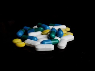 Medical pills on black background