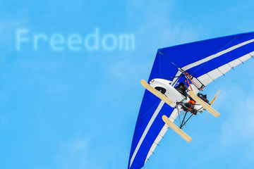 The motorized hang glider in the blue sky. Freedom, success, vacation, business concepts