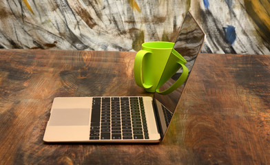 Fototapeta na wymiar Laptop Smart with Green Coffee Cup in back