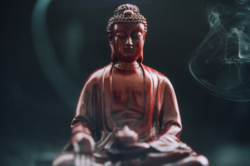 Buddha-Statue mit Weihrauch. Gottheit und Symbole des Buddhismus. Die Praxis des Buddhismus und seine Symbole. Spirituelles Leben Asiens