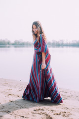 beautiful hippie girl walking near the shore girl in a dress, co