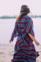 beautiful hippie girl walking near the shore girl in a dress, co
