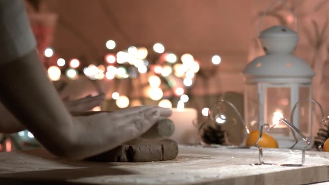 Female hand rolled fresh dough on the table with the help of a rolling pin. Dolly shot. Fresh flour is scattered around. fresh ginger dough for the Gingerbread cookie. close up, dolly shot. Bokeh back