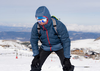 Fototapeta na wymiar tired man exhausted after peak summit trekking achievement in snow mountain winter landscape