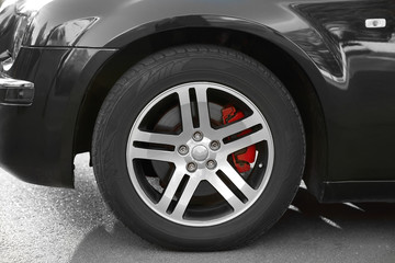 Wheel of luxury black car, closeup