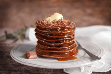 Tasty pancakes with chocolate sauce on plate
