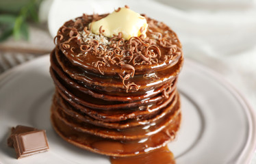 Tasty pancakes with chocolate sauce on plate