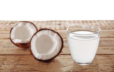 Glass of coconut milk and nuts on wooden table