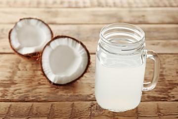 Glass of coconut milk and nuts on wooden table