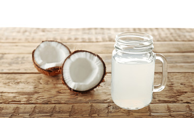 Glass of coconut milk and nuts on wooden table