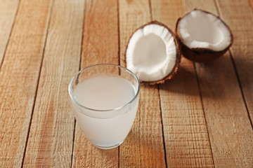 Glass of coconut milk and nuts on wooden table