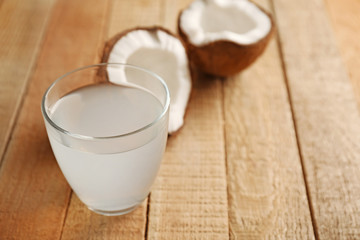 Glass of coconut milk and nuts on wooden table